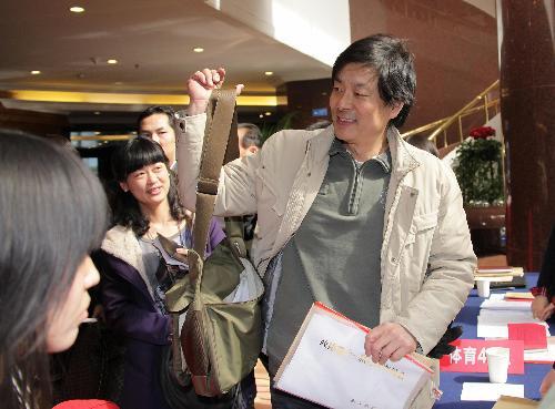 Pu Cunxin (R), a member of the 11th National Committee of the Chinese People's Political Consultative Conference (CPPCC) and also a famous actor in China, registers his arrival for the annual session of CPPCC National Committee at Beijing International Hotel in Beijing, China, March 2, 2010. Pu went to register his arrival by bicycle on Tuesday.(Xinhua/Xing Guangli)