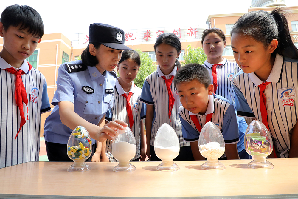 2025年6月24日,山东滨州博兴县公安局禁毒大队民警在博兴县实验小学通过毒品模型指导小学生辨认毒品。