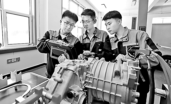 甘肃省张掖市高台职业中等专业学校,同学们在进行新能源汽车变速器检查操作实训演练。王将摄/光明图片