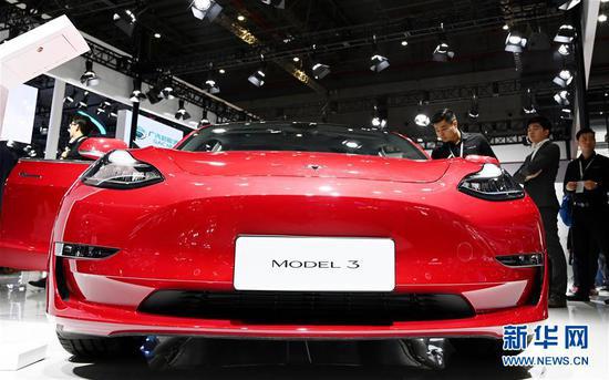 参观者在上海车展特斯拉展台观看一部展出的Model 3电动车，这也是即将在上海特斯拉工厂生产的车型（4月17日摄）。 新华社记者 方喆 摄