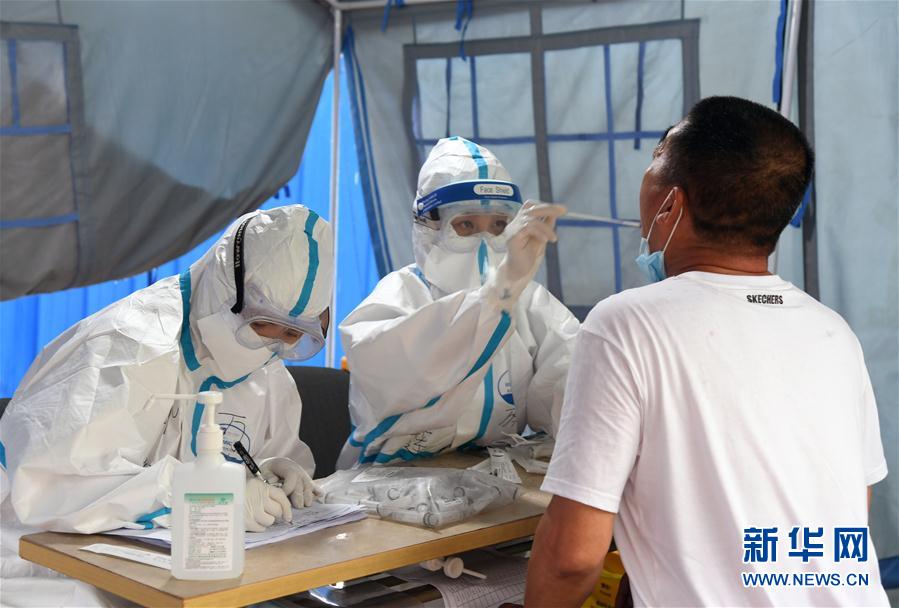 6月18日，在海淀区区级核酸检测采样点，医护人员为市民进行核酸检测采样。 新华社记者 任超 摄