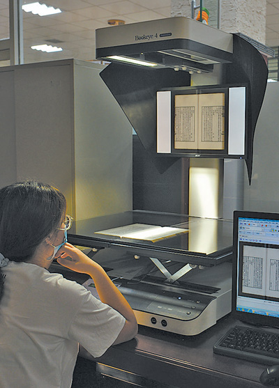 内蒙古图书馆，工作人员正在将古籍进行数字化管理。