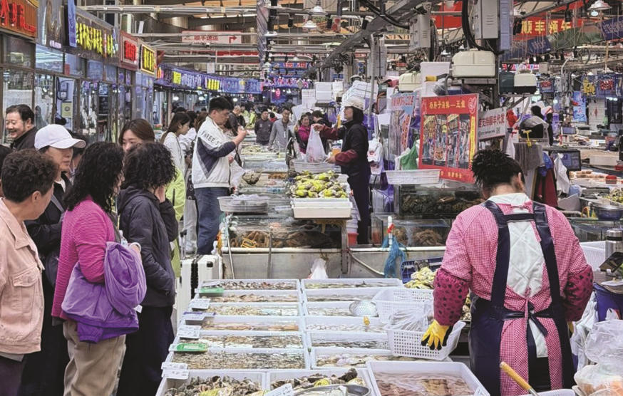 图为青岛团岛农贸市场内，消费者选购海鲜产品。